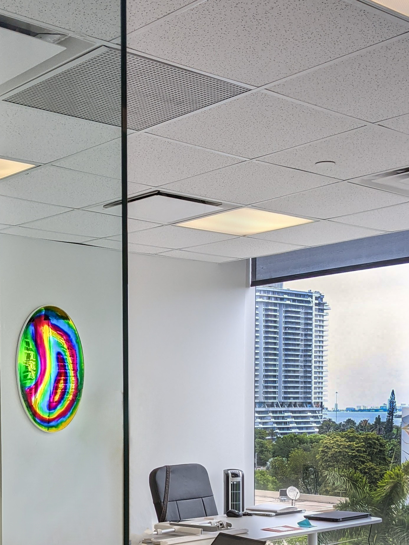 Purple Office – Rainbow Mirror 0654 (2021) by Haiiileen – iridescent oval mirror installed in a Miami office, refracting sunlight into vivid spectral hues.