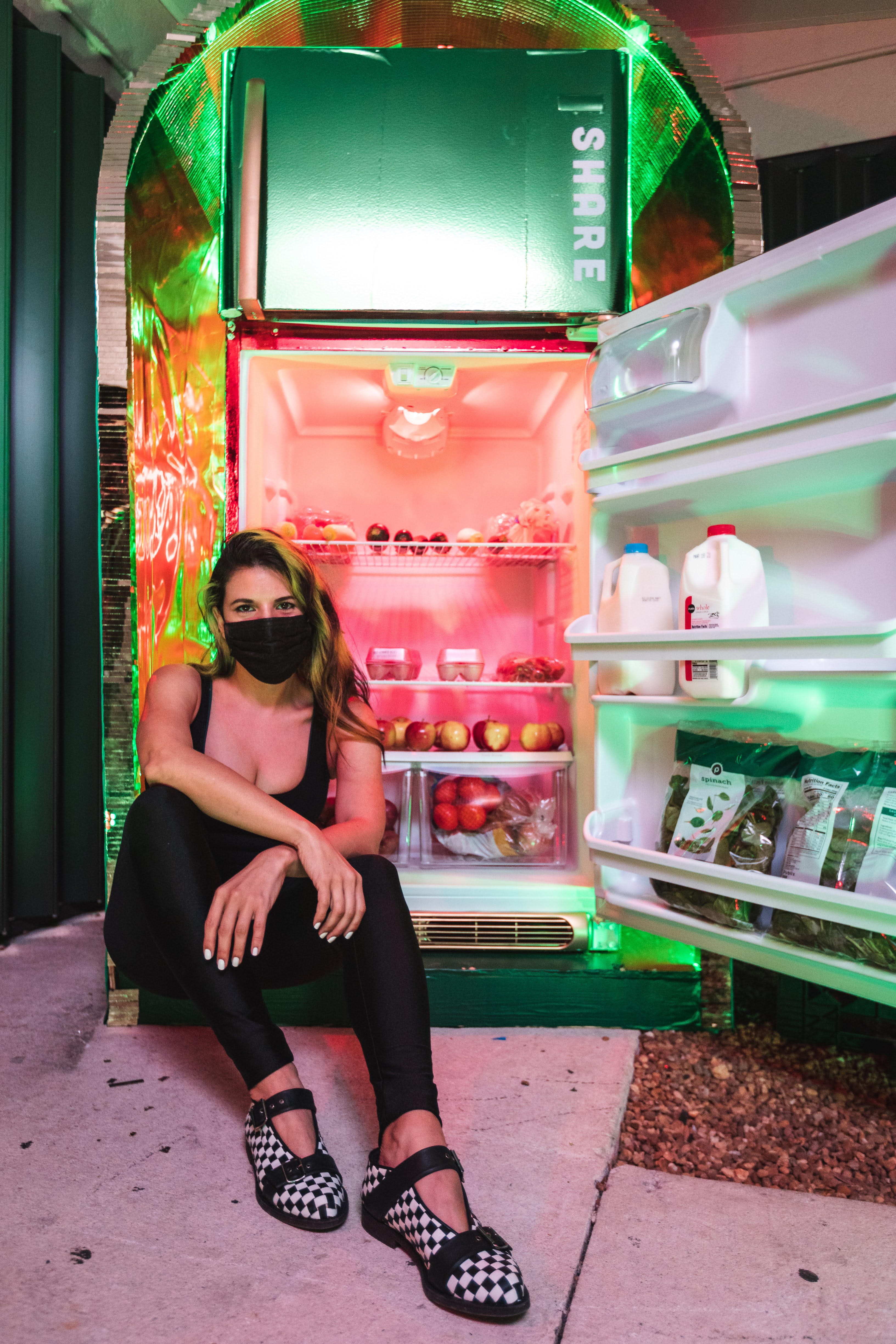 Haiiileen installing a neon-lit sculptural community fridge for Miami Community Fridge and Buddy System MIA.