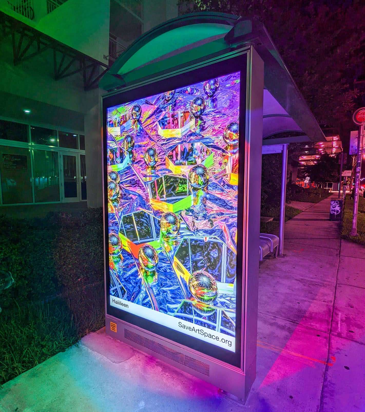 Wynwood Public Art Display (2020) by Haiiileen – illuminated bus stop installation featuring a multicolored reflective artwork, exhibited during Miami Art Week.